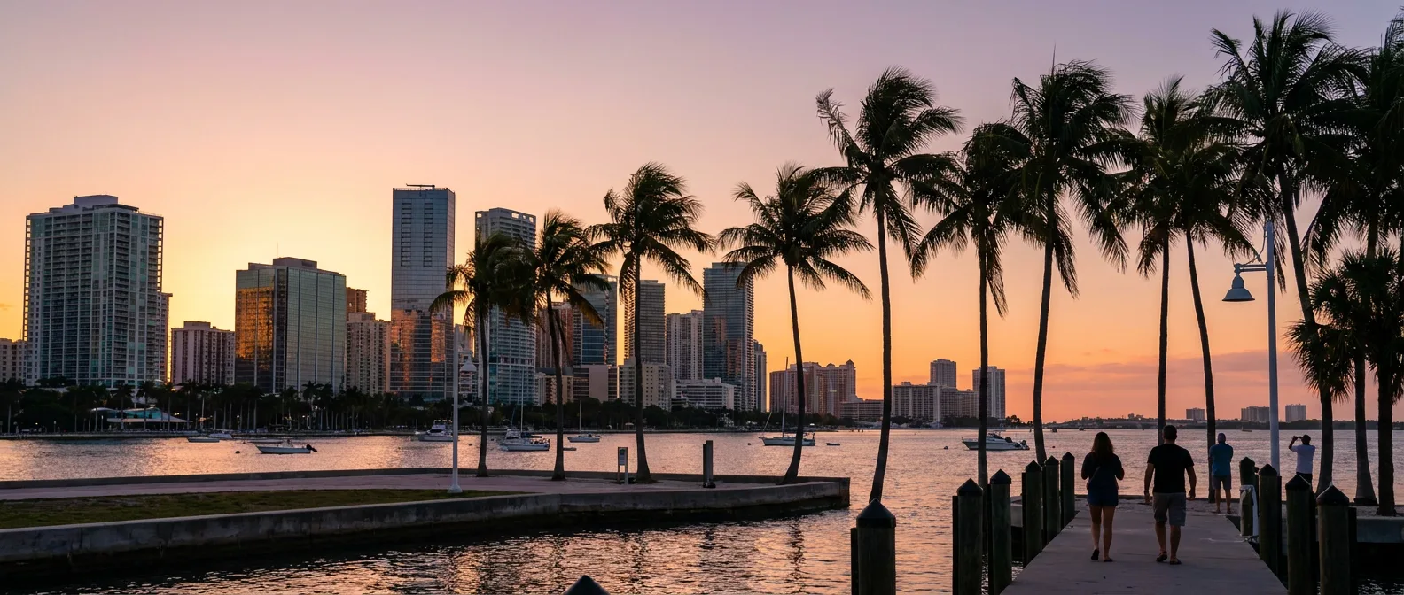 Florida waterfront city skyline at sunset with palm trees along the bay